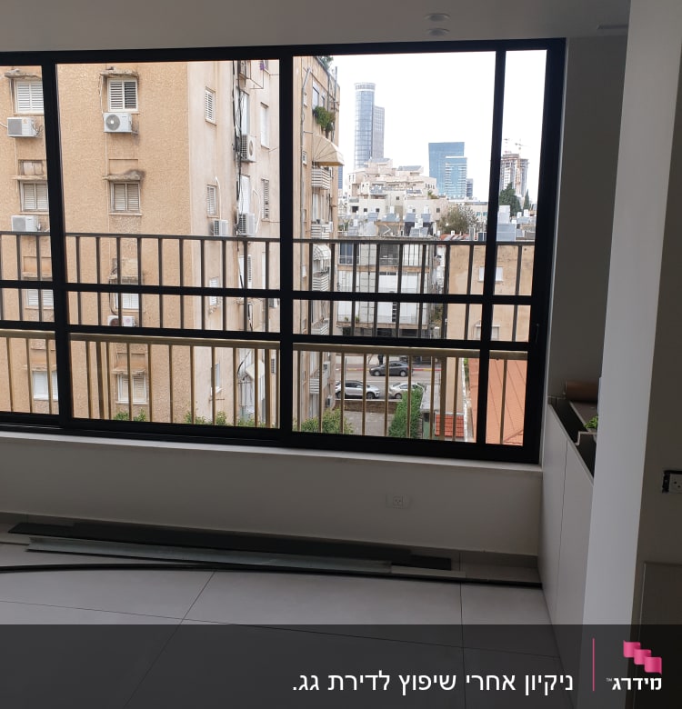 רצפה נקייה ליד חלון גדול עם נוף עירוני